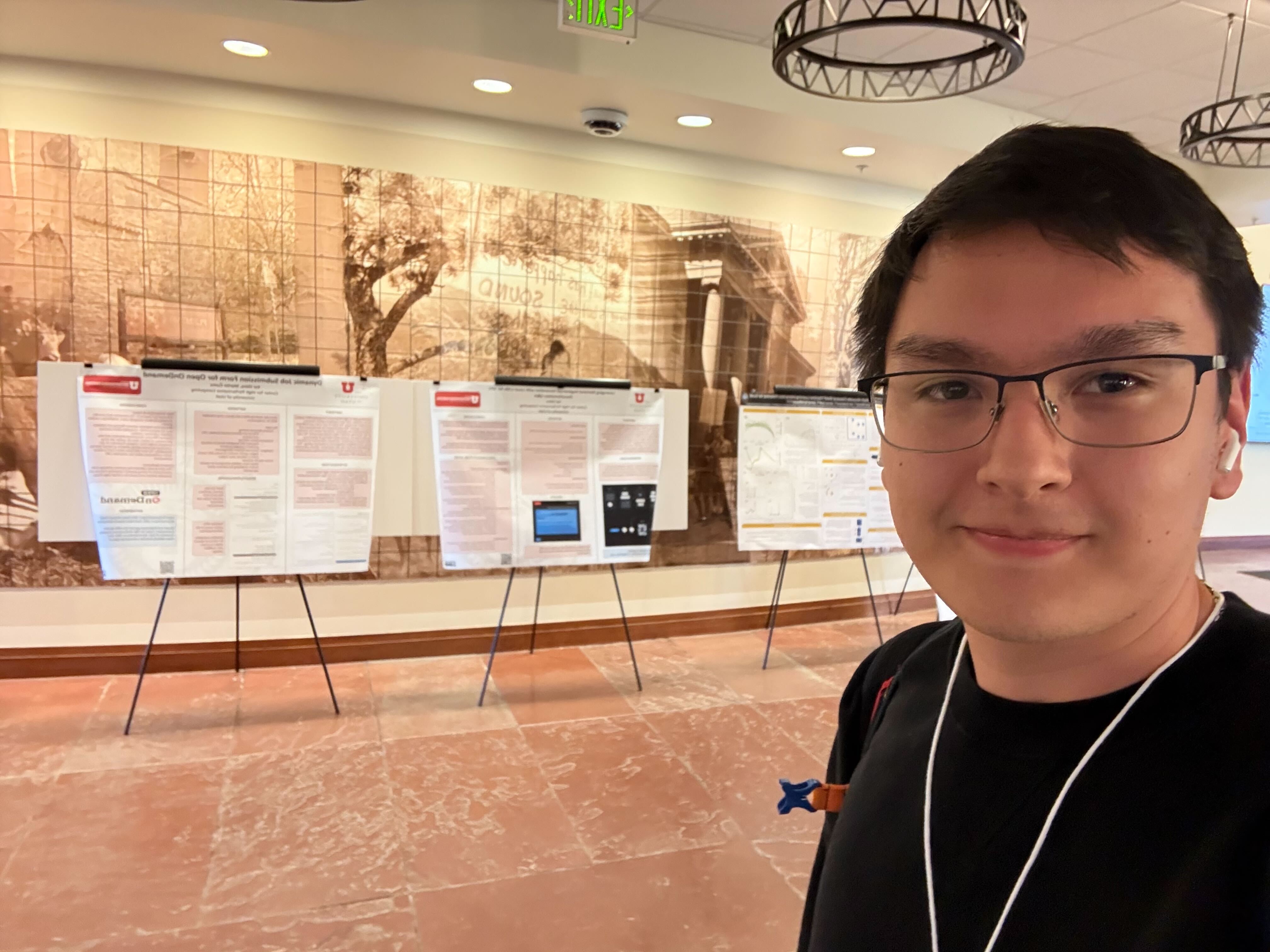 Kai Ebira stands with his poster at the RMACC HPC Symposium
